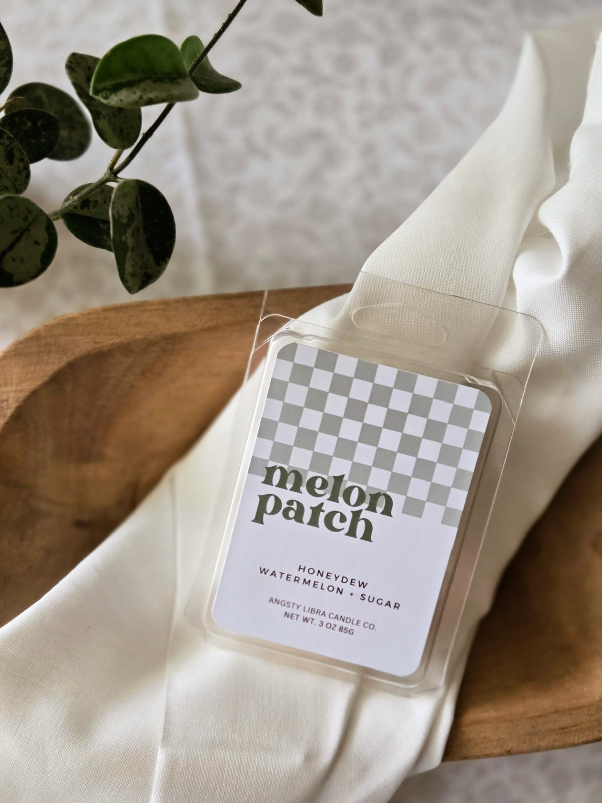 Melon Patch wax melts with a checkered label on a wooden surface
