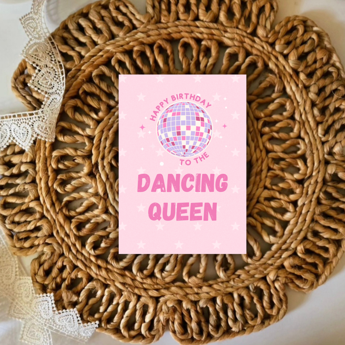 Pink birthday card with disco ball design on a woven mat