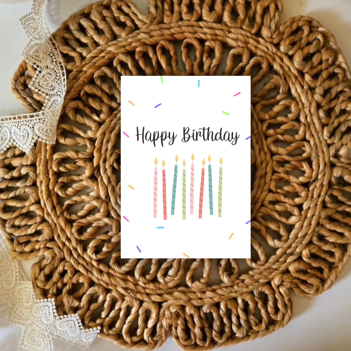 Round woven placemat with a 'Happy Birthday' card featuring candles on a white background