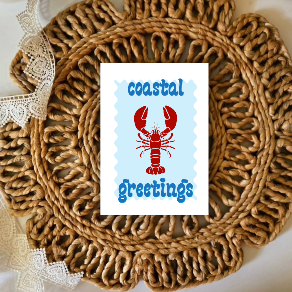 Round woven placemat with a card featuring a lobster and 'coastal greetings' text.