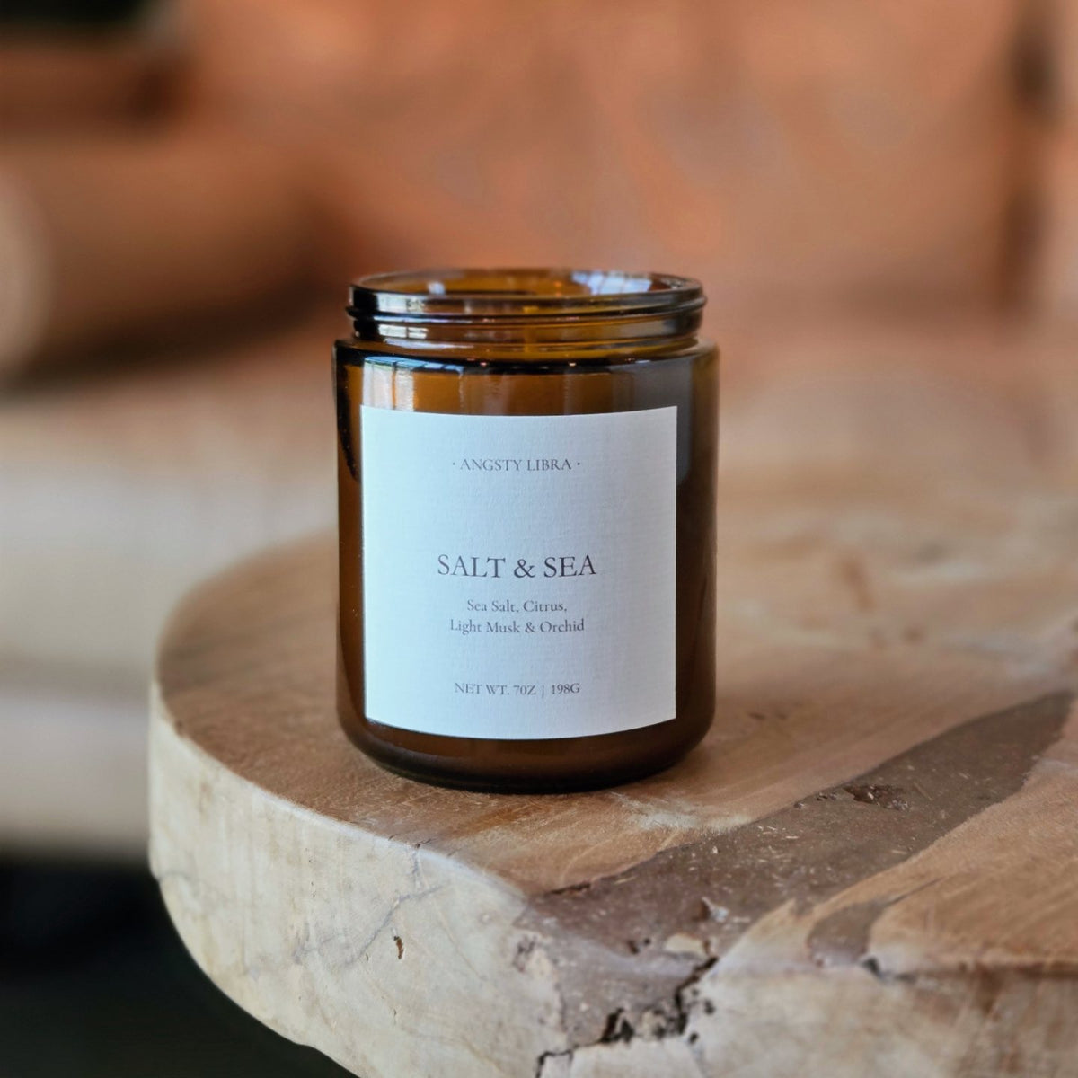 Candle jar labeled 'Salt & Sea' on a wooden surface